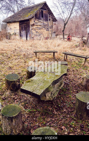 Serbische alte traditionelle Hausgarten mit improvisierter Tisch und Stühlen Stockfoto