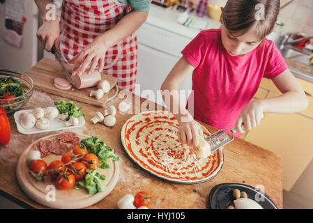 Mutter und Tochter, die Pizza in der Küche vorbereiten Stockfoto