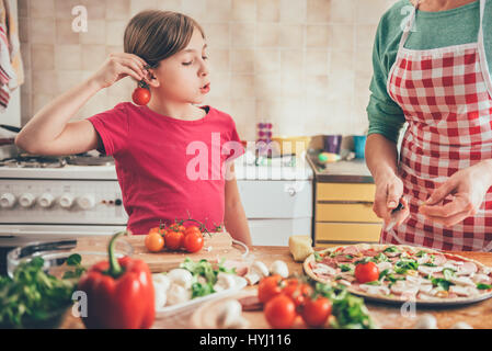 Mutter und Tochter, die Pizza in der Küche vorbereiten Stockfoto