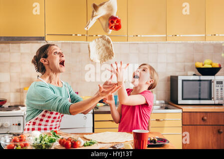 Mutter und Tochter, die Pizza in der Küche vorbereiten Stockfoto