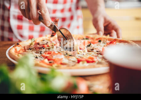 Frau schneiden frisch gebackene pizza Stockfoto