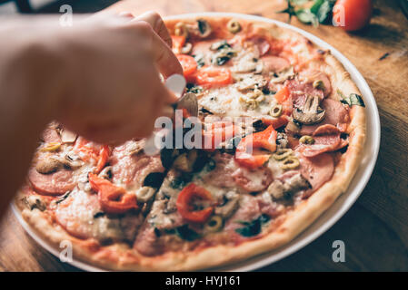 Frau schneiden frisch gebackene pizza Stockfoto