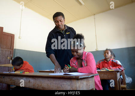 Lehrer helfen, eine Schülerin, 15 Jahre, Grundschule, Fianarantsoa, Madagaskar Stockfoto