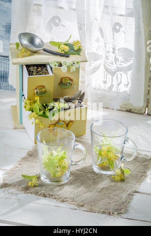 Linden-Tee mit Honig in Sonnentag am weißen Tisch Stockfoto