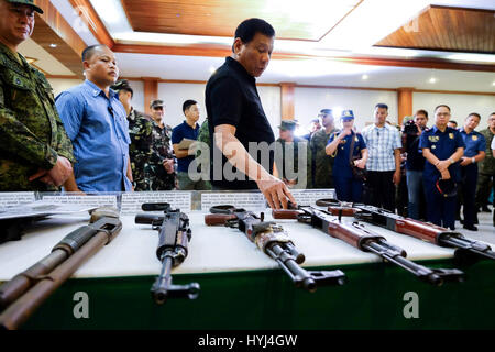 Philippinische Präsident Rodrigo Duterte untersucht Schusswaffen beschlagnahmt von der neuen Völker Armee während eines Besuchs in der 4. Infanterie Division Hauptquartier Camp Evangelista 2. April 2017 in Manila, Philippinen. Stockfoto