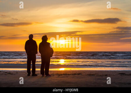 Southport, Merseyside, England. 4. April 2017. Großbritannien Wetter.  Farbenfrohen Sonnenuntergang über die irische See als Menschen an der Küste genießen Sie die Strahlen der untergehenden Sonne am Horizont von der Mündung des Mersey.  Kredite; MediaWorldImages/AlamyLiveNews Stockfoto