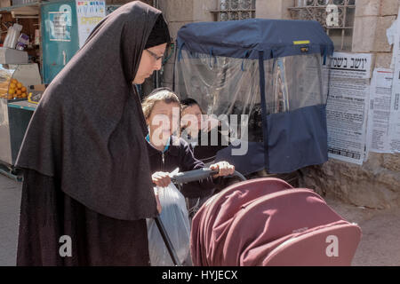 Jerusalem, Israel. 5. April 2017. Eine Mutter und Kinder sind unterwegs im Stadtteil Mea Shearim huschen in Vorbereitung für Pessach, heuer Anfang Sonnenuntergang, 10. April 2017 gefeiert werden.  Mea Shearim ist eines der ältesten jüdischen Viertel in Jerusalem und völlig von ultra-orthodoxen Haredi Juden bevölkert. Bildnachweis: Nir Alon/Alamy Live-Nachrichten Stockfoto