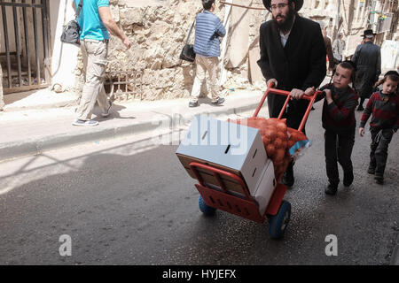 Jerusalem, Israel. 5. April 2017. Ein Vater und Kinder sind unterwegs im Stadtteil Mea Shearim huschen in Vorbereitung für Pessach, heuer Anfang Sonnenuntergang, 10. April 2017 gefeiert werden. Mea Shearim ist eines der ältesten jüdischen Viertel in Jerusalem und völlig von ultra-orthodoxen Haredi Juden bevölkert. Bildnachweis: Nir Alon/Alamy Live-Nachrichten Stockfoto