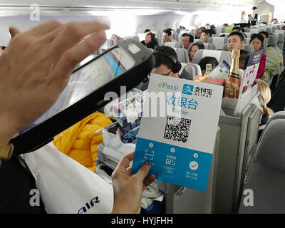 (170405)--Peking, 5. April 2017 (Xinhua)--A Finnair Stewardess verwendet Chinas Alipay auf einem Flug von Peking nach Helsinki am 29. März 2017. Finnische Fluggesellschaft Finnair eröffnet Direktflug Route zwischen Helsinki und Beijing 1988, das als erstes aus Europa nach China. Das Projekt war ein Pionier und viele große europäische Fluggesellschaften folgten. Fast bleibt 30 Jahre später Finnair unter die Top fünf europäischen Fluggesellschaften in China. Es fliegt einige 30 Direktflüge nach sechs chinesischen Destinationen pro Woche im Durchschnitt. Im Januar 2017 begann es ein Pilotprojekt Installation Alipay auf fli Stockfoto