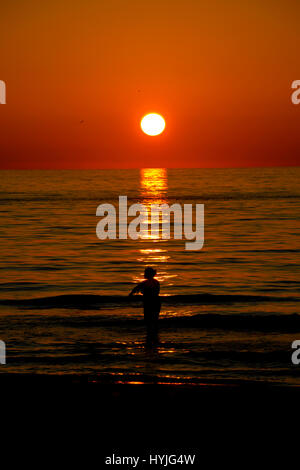Sonnenuntergang am Meer mit Silhouette Menschen Stockfoto