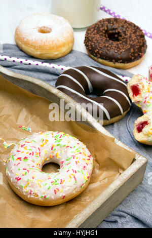 Schokolade Donut mit Wachspapier und Getränk auf Holztisch Schokolade Donut mit Wachspapier und Getränk auf Holztisch