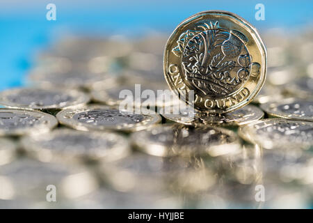 neue Pfund-Münze eingeführt in Großbritannien im Jahr 2017, Front, stehend auf einer Schicht von Münzen und auf blauem Hintergrund Stockfoto