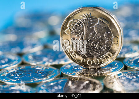 neue Pfund-Münze eingeführt in Großbritannien im Jahr 2017, Front, stehend auf einer Schicht von Münzen und auf blauem Hintergrund Stockfoto