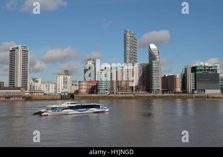 Ein Thames Clipper auf der Themse übergibt New Providence Wharf, am nördlichen Ufer der Themse in London Docklands, UK. Stockfoto