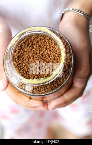 Nahaufnahme von Hand hält ein Glas Kaffee-Granulat Stockfoto