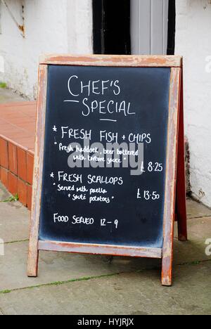 Eine Tafel vor einem Pub Werbung Köche Spezialitäten auf der Speisekarte bei Roggen in East Sussex, England. Stockfoto