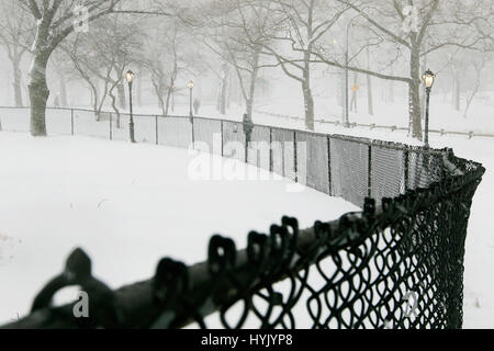 Ein Blick auf den Central Park bei starkem Schneefall. Fußgänger sind im Hintergrund zu sehen. Stockfoto