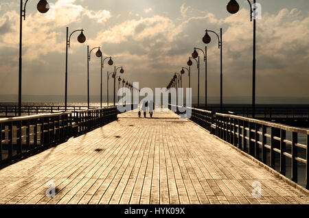 Holzsteg mit Laternen an der Ostsee in Jurata, Polen bei Sonnenuntergang spazieren Stockfoto