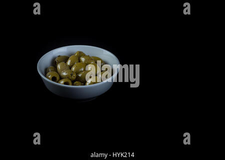 Oliven sehr frisch, gewürzt und zubereitet in Na weiße Schüssel in schwarzem Hintergrund isoliert Stockfoto