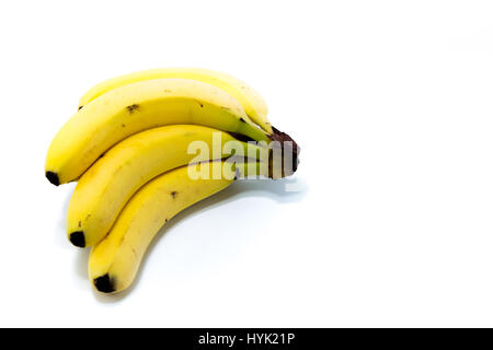 Vier frische goldene Bananen mit zwei Erdbeeren in weißen Hintergrund isoliert Stockfoto