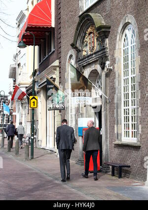 Männer zu Fuß hinter dem Eingang des Museums Gouda im 17. Jahrhundert Catharina Gasthuis Gebäude am Oosthaven Kanal, Gouda, Niederlande Stockfoto