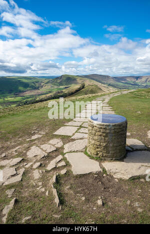 Die Säule auf dem Gipfel des verlieren, Derbyshire, Bergblick auf dem asphaltierten Weg zur Mam Tor an einem sonnigen Frühlingstag. Stockfoto