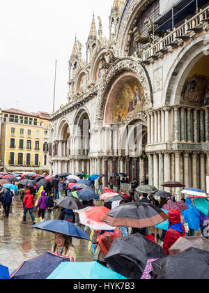 Touristen mit Sonnenschirmen auf einem nassen und regnerischen Tag in Markusplatz entfernt (Piazzetta di San Paulo), Venedig, Italien Stockfoto