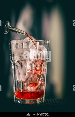 Roten süßes Getränk Gießen auf Eiswürfel Stockfoto