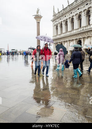 Touristen mit Sonnenschirmen auf einem nassen und regnerischen Tag in Markusplatz entfernt (Piazzetta di San Paulo), Venedig, Italien Stockfoto