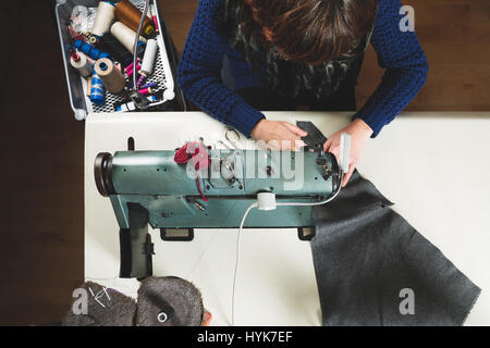 Schneiderin mit einem professionellen Nähmaschine nähen. Ansicht von oben. Stockfoto
