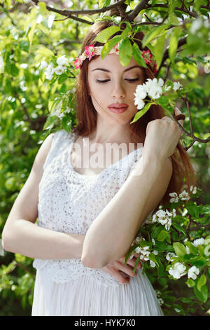 Schöne Frau in einem blühenden Obstgarten. Saisonale Frühling Stockfoto