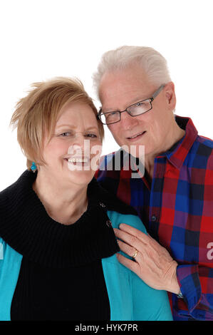 Eine schöne älteres Ehepaar im lässigen Tuch stehen, einander umarmen, isoliert lächelnd, weißen Hintergrund. Stockfoto