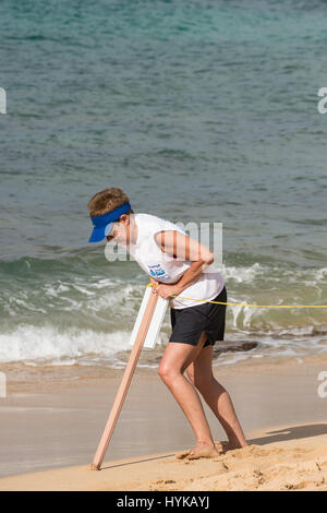 Ein freiwilliger setzt Zeichen zu halten Menschen weg von eine hawaiianische Mönchsrobbe, Neomonachus Schauinslandi am Poipu Beach, Kauai, Hawaii, USA Stockfoto