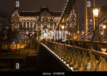 Perspektive Nachtansicht mit Kettenbrücke, Gresham Palace und Saint Stephen Basilica in Budapest Stockfoto