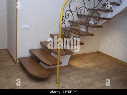 Metallische Beige String - ein Entwurf für den Bau der Treppe im Haus. Holztreppen und Geländer Metall Maßwerk geschmiedet. Stockfoto