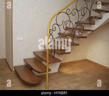 Metallische Beige String - ein Entwurf für den Bau der Treppe im Haus. Holztreppen und Geländer Metall Maßwerk geschmiedet. Stockfoto