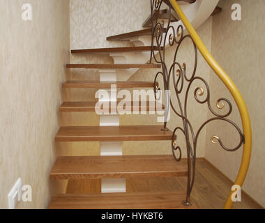 Metallische Beige String - ein Entwurf für den Bau der Treppe im Haus. Holztreppen und Geländer Metall Maßwerk geschmiedet. Stockfoto