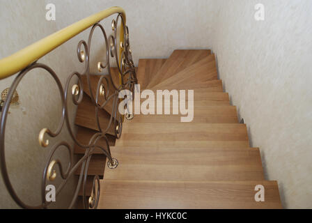 Metallische Beige String - ein Entwurf für den Bau der Treppe im Haus. Holztreppen und Geländer Metall Maßwerk geschmiedet. Stockfoto