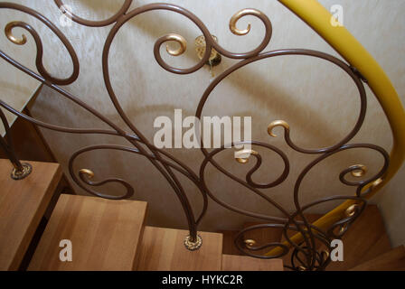 Metallische Beige String - ein Entwurf für den Bau der Treppe im Haus. Holztreppen und Geländer Metall Maßwerk geschmiedet. Stockfoto