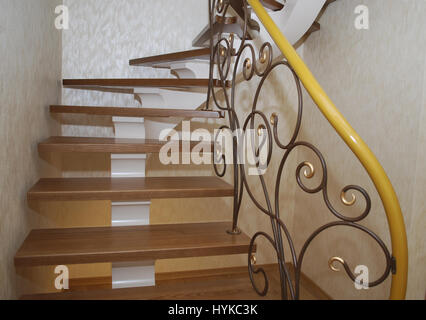 Metallische Beige String - ein Entwurf für den Bau der Treppe im Haus. Holztreppen und Geländer Metall Maßwerk geschmiedet. Stockfoto