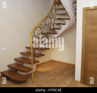 Metallische Beige String - ein Entwurf für den Bau der Treppe im Haus. Holztreppen und Geländer Metall Maßwerk geschmiedet. Stockfoto