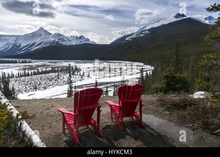 Red Adirondack Stühle und Green Forest. Howse River Glacier Lake Hiking Trail Rocky Mountains Canada Banff National Park Stockfoto