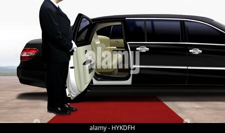 Fahrer warten und stehen neben der schwarzen Limousine auf einem roten Teppich Stockfoto