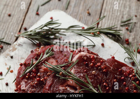 Würze. Rohes Fleisch auf dem Schneidebrett Stockfoto