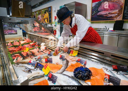 Eine junge Frau Mädchen "Kollege" arbeiten im Bereich Frischfisch des Bereichs frische Lebensmittel an einem Seitenarm des Tesco Supermarkt speichern UK Stockfoto