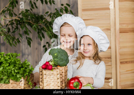 Hübscher Junge und schöne junge Mädchen spielen in der Küchenchefs. Gesunde Ernährung. Gemüse Stockfoto