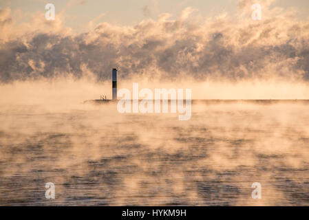 LAKE MICHIGAN, USA: Der Sonne prallen obwohl dieser nebligen Morgengrauen um ein unglaublich kalt minus 19 Grad Celsius macht dieses Sees am Feuer aussehen. Bekannt als "Meer Rauch" zeigen die Bilder schwere Nebel ein natürliches Phänomen, verursacht, wenn warme Wasserdampf trifft auf kalten Luft und erstellen einen unheimlichen Nebel kondensiert. Schönen Aufnahmen wurden von britischen Amateur-Fotografen, Bob Small, ursprünglich aus Somerset, genommen aber jetzt in der Nähe der amerikanischen See basiert. Stockfoto