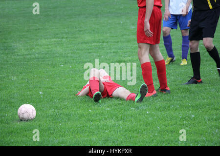 Verletzte Spieler beim Fußballspiel auf dem Rasen liegend Stockfoto