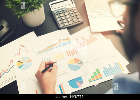 Business-Analyse - Mann mit Finanzdaten Diagrammen im Büro arbeiten Stockfoto