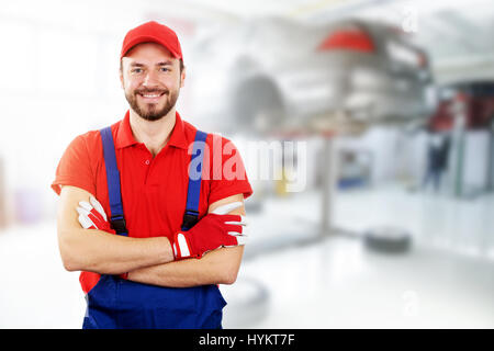 glücklich Auto Mechaniker stehend in Auto-Werkstatt Stockfoto